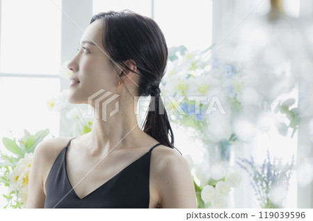 窗邊穿著黑色吊帶背心洋裝的女人 119039596