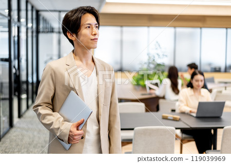 一名商人腋下夾著一台電腦，面向斜左。 119039969