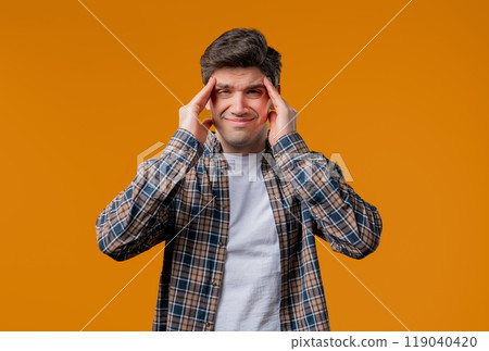 Mature man having hypertension headache, yellow studio.Guy putting hands on head Mature man having hypertension headache, yellow studio.Guy putting hands on head 119040420