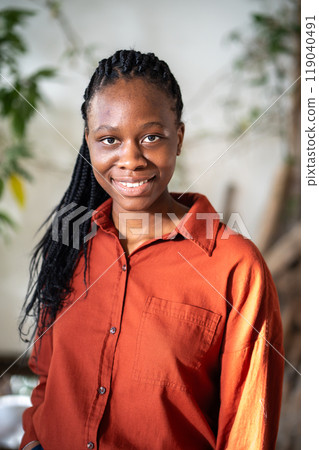Portrait of pleased african american girl with braids smiling looking at camera with confident gaze. 119040491