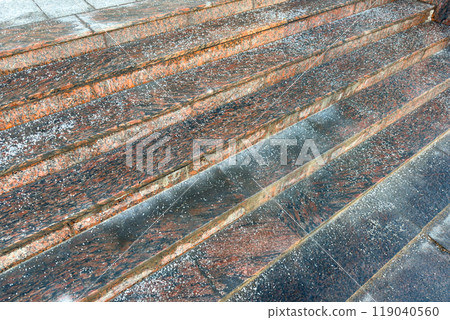Deicing chemicals on stairs in winter. Salt grains on icy stone steps in cold season Deicing chemicals on stairs in winter. Salt grains on icy stone steps in cold season 119040560