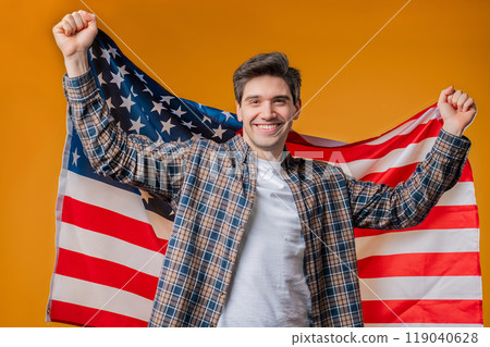 Happy mature man with national USA flag on yellow background. American patriot Happy mature man with national USA flag on yellow background. American patriot 119040628