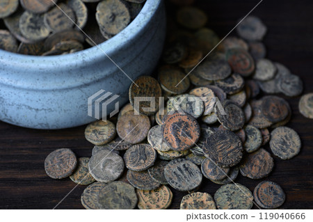 Many Roman coins on old dark wooden table, Ancient money hoard, vintage background. Concept of pile, antique, Empire, texture and history Many Roman coins on old dark wooden table, Ancient money hoard, vintage background. Concept of pile, antique, Empire, texture and history 119040666