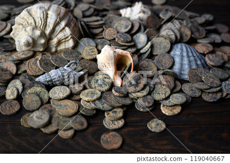 Pile of Roman coins and shells on old dark wooden table, Ancient money hoard from sea, vintage background. Concept of antique, Empire, texture, civilization Pile of Roman coins and shells on old dark wooden table, Ancient money hoard from sea, vintage background. Concept of antique, Empire, texture, civilization 119040667