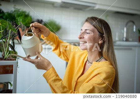 Merry plant lover woman doing household duties, taking care of potted houseplants, watering flowers Merry plant lover woman doing household duties, taking care of potted houseplants, watering flowers 119040880