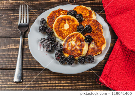 Cottage cheese pancakes with fresh blackberries on a white flat white plate Cottage cheese pancakes with fresh blackberries on a white flat white plate 119041400
