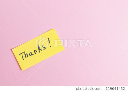Yellow small note with the word thank you on a pink background in the center 119041432