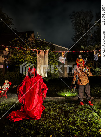 Halloween decorations in front of a house in the middle of a suburban neighborhood 119043604