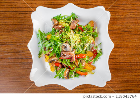 Fresh salad with seafood, baked potato and vegetables on white plate on wooden table top view Fresh salad with seafood, baked potato and vegetables on white plate on wooden table top view 119043764