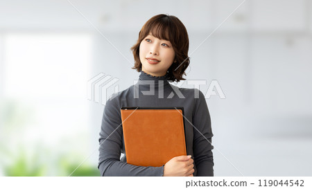 Businesswoman smiling with a file Businesswoman smiling with a file 119044542