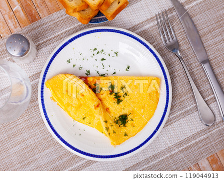 Fuffy omelet with chopped dill and toasts 119044913