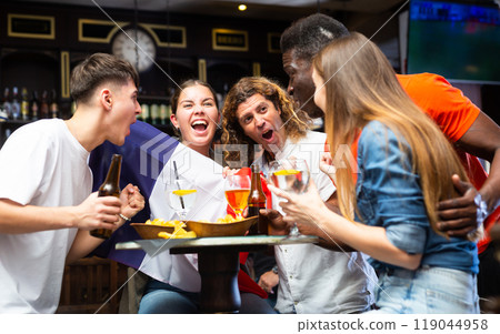 Excited diverse football supporters with flag of France watching tournament with beer and snacks in the pub Excited diverse football supporters with flag of France watching tournament with beer and snacks in the pub 119044958