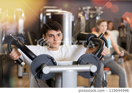 Young athlete is engaged in a power simulator in gym Young athlete is engaged in a power simulator in gym 119044996