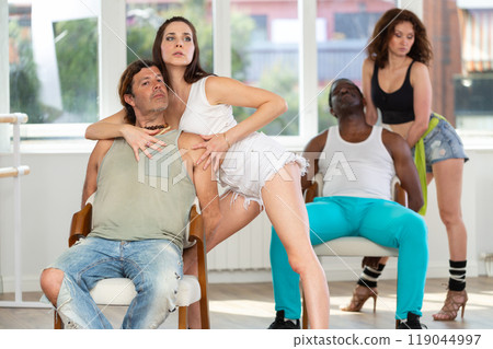 Man sits on chair and enjoys female company and charming lap dance. 119044997