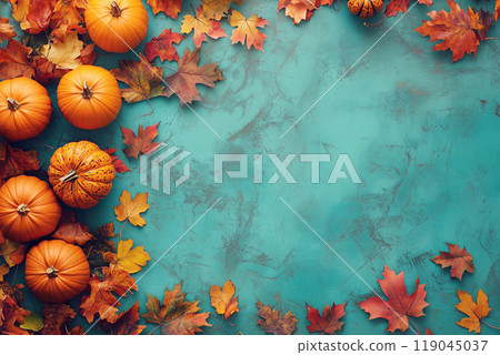 Pumpkins and vibrant autumn leaves arranged on a textured turquoise background, evoking a festive fall and Thanksgiving vibe. 119045037