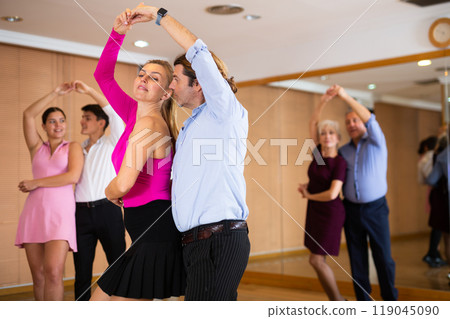 Happy couple performing a paired dance in ballroom Happy couple performing a paired dance in ballroom 119045090