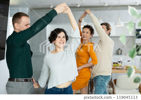 Men and women dancing during house party. 119045113