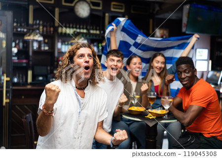 Enthusiastic Greek fans scream with joy in beer bar. Greece win 119045308