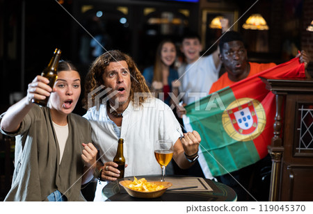 Excited couple rooting for favorite Portuguese team in sports bar 119045370