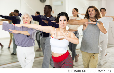 Young Hispanic woman learning dynamic dances in choreography class Young Hispanic woman learning dynamic dances in choreography class 119045475