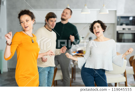 Men and women doing couple dancing during house party. 119045555