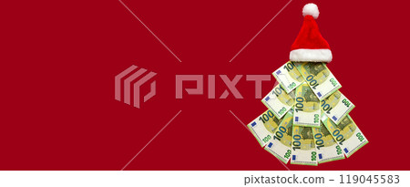 Banner, 100 euro bills folded in the shape of a Christmas tree with a Christmas hat instead of a star, symbolizing the financial priorities and considerations that define the holiday season 119045583