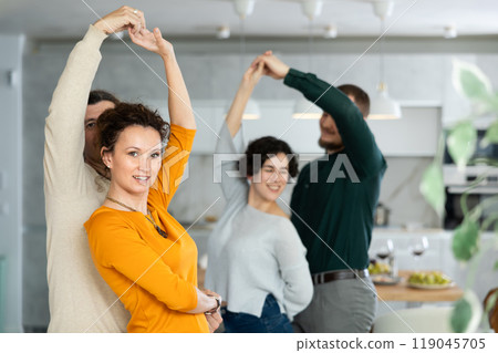 Four adult friends dancing and singing at home. Cheerful women and men enjoy music together. Happy people celebrating friendship Four adult friends dancing and singing at home. Cheerful women and men enjoy music together. Happy people celebrating friendship 119045705