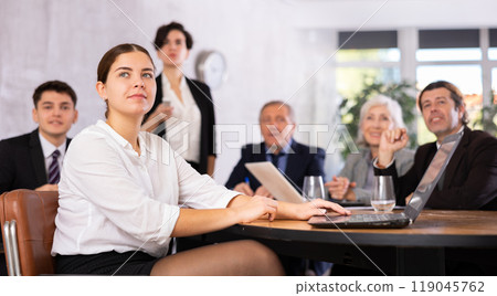 Woman and man sitting at table beside during meeting in conference room 119045762