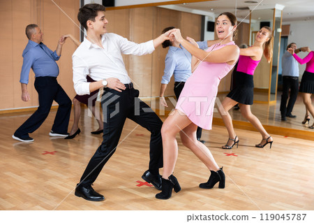Young couple practicing vigorous lindy hop in choreography class Young couple practicing vigorous lindy hop in choreography class 119045787