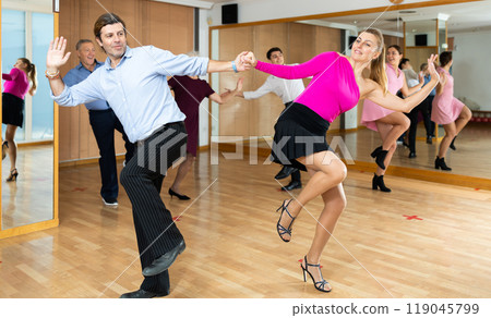 Happy couple performing a paired dance in ballroom 119045799