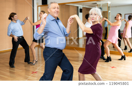 Senior woman and man enjoying lindy hop in dance studio Senior woman and man enjoying lindy hop in dance studio 119045801