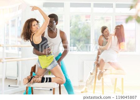 Group modern lap dance training for couples using a chair in studio Group modern lap dance training for couples using a chair in studio 119045807