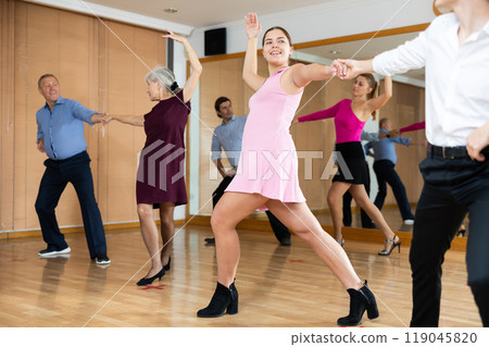 Young girl enjoying swing with partner in dance studio 119045820