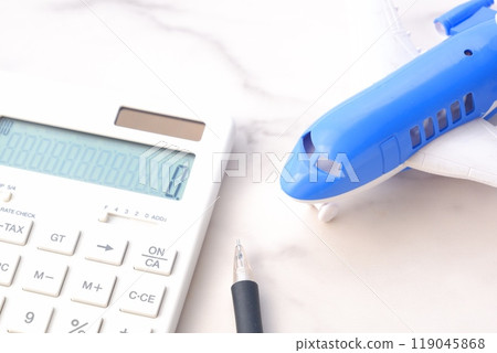 Image of planning a trip with a calculator and an airplane 119045868