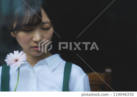 一位年輕的女店員透過玻璃，表情憂鬱 119046350