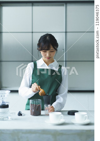 週末早上,一位年輕的女店員正在煮咖啡 週末早上,一位年輕的女店員正在煮咖啡 119046375