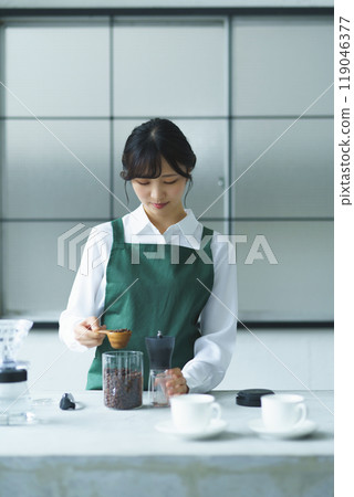 A young female sales clerk brewing coffee on a weekend morning A young female sales clerk brewing coffee on a weekend morning 119046377