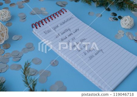 New year's resolutions on paper note with Christmas decor. Making promises for new year, setting goals. Creating dream vision board New year's resolutions on paper note with Christmas decor. Making promises for new year, setting goals. Creating dream vision board 119046718