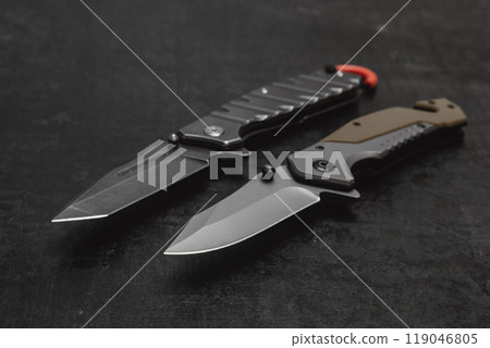 Two opened tactical military knives with sharp blade. Tool on dark concrete background. 119046805