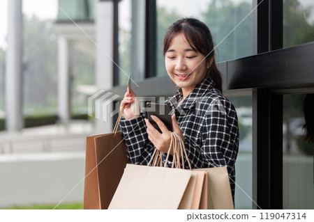 Digital Consumer Engaging in Black Friday Shopping with Card and Phone Digital Consumer Engaging in Black Friday Shopping with Card and Phone 119047314
