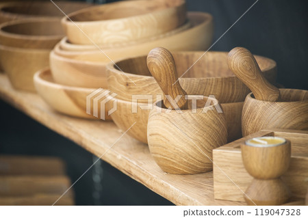 Handcrafted wooden bowls and mortars with pestles on display showcasing exquisite craftsmanship 119047328