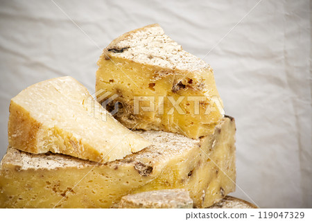 aged cheese wedges with rustic texture on white showcasing artisanal craftsmanship and rich flavor 119047329