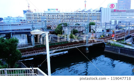 View of Yokohama West Exit at dusk near the Katabira River that flows around Yokohama Station 119047718