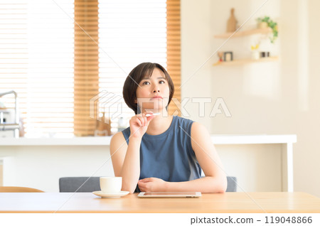 一個女人手裡拿著觸摸筆思考 一個女人手裡拿著觸摸筆思考 119048866