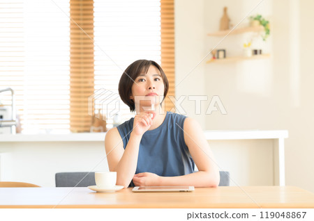 一個女人手裡拿著觸摸筆思考 一個女人手裡拿著觸摸筆思考 119048867