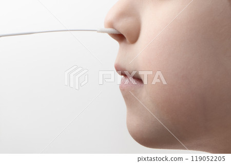 swab into a Children nose to collect COVID-19 sample during the pandemic. Antigen test procedure. Close up swab into a Children nose to collect COVID-19 sample during the pandemic. Antigen test procedure. Close up 119052205