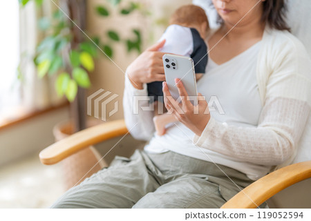 A housewife who can't stop using her smartphone while holding her child 119052594