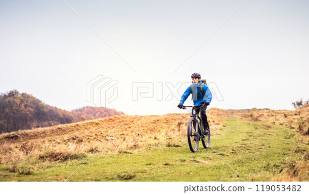 Active man on bike in the middle of beautiful nature, early autumn morning. Concept of healthy lifestyle. 119053482