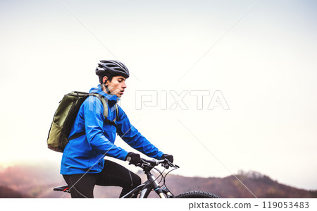 Active man on bike in the middle of beautiful nature, early autumn morning. Concept of healthy lifestyle. 119053483