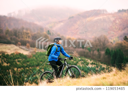 Active man on bike in the middle of beautiful nature, early autumn morning. Concept of healthy lifestyle. 119053485